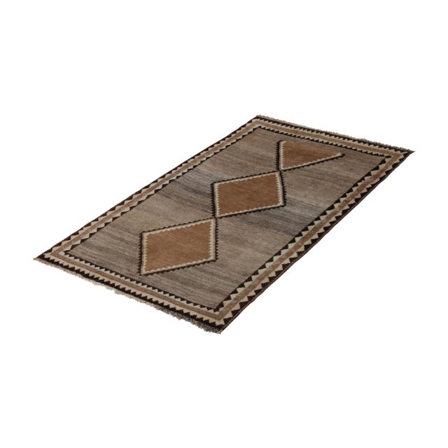 Made in hand-knotted wool originating circa 1950-1960, this vintage Persian rug connotes a mid-century Gabbeh rug design,...