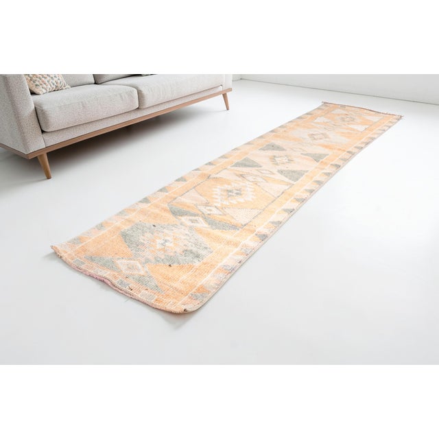 This is a vintage Turkish Oushak rug from the Mid 20th Century. The piece was hand-knotted.
