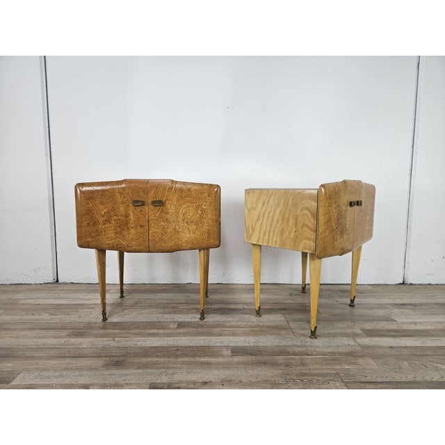 An elegant pair of bedside tables dating back to the 1950s, featuring soft, rounded lines typical of period design. Made...