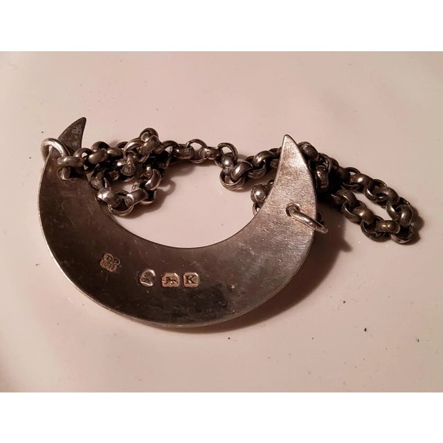 This crescent shaped bottle tag was made in 1797 by Thomas Phipps and Ed Robinson in London England. This sterling silver...