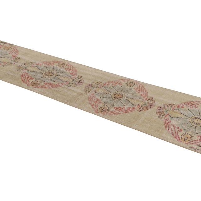 This vintage runner rug is a 2x10 Turkish distressed piece, made with hand-knotted wool circa mid-20th century. It is an...