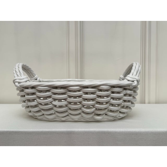 Glossy finished glazed earthenware in white creates a monochromatic flow of color throughout the handmade basket....