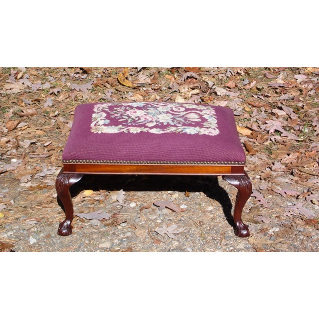 Antique Footstool Ottoman has Needlepoint with Burgundy background and floral bouquet center motif. Solid Mahogany base in...