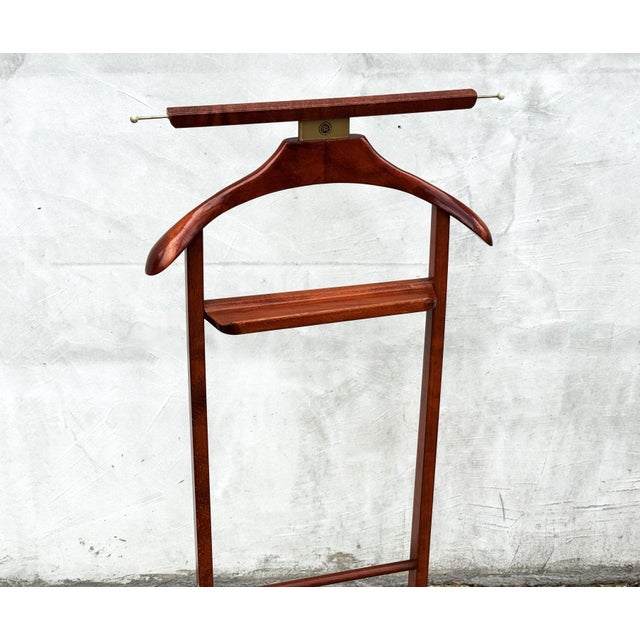 Elegant Italian valet stand by Fratelli Reguitti, crafted in solid wood with brass accents and classic mid-century...