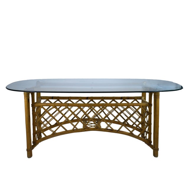 An organic bamboo and rattan dining table, its natural poles and woven construction full of handcrafted, free-form...