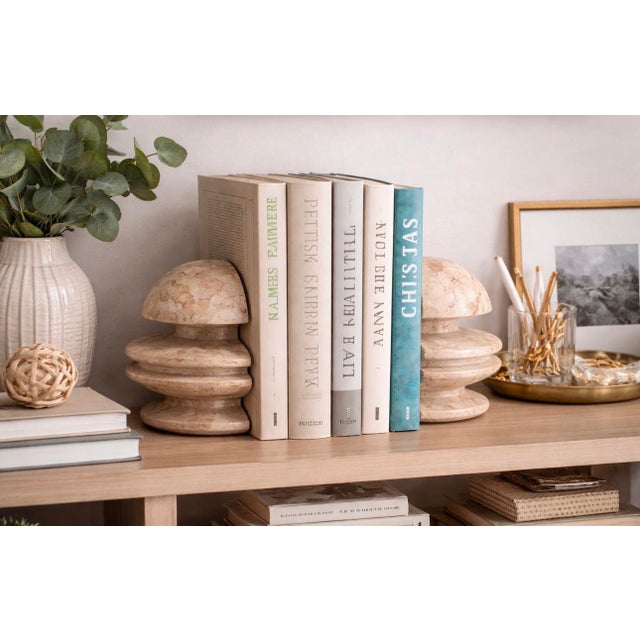 A striking pair of vintage travertine sculptural bookends featuring a bold layered architectural form carved from solid...