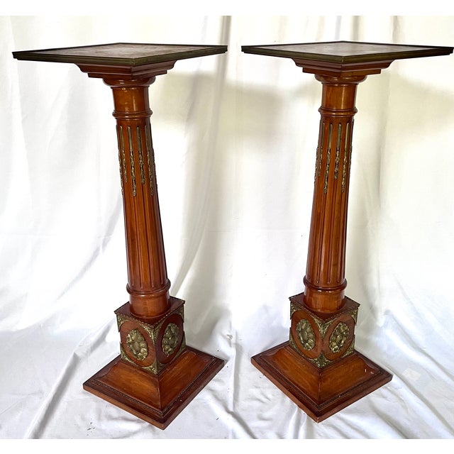 Pair of antique mahogany pedestal/plant stands. Italian Meroni style fluted columns with gilt ormolu accents on the...