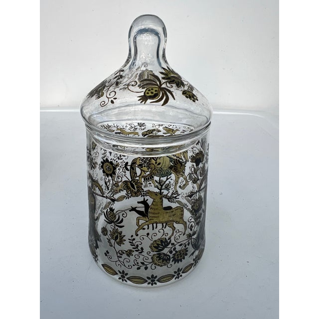 Vintage glass jar featuring a hand-painted medieval or gypsy-style motif. The clear glass jar is decorated with gold and...