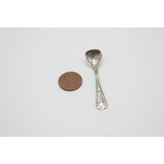 This is an adorable silver salt cellar spoon. It has small leaf detailing on the handle. Marked 800 crescent moon and...