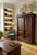 An exceptionally crafted, large antique-style wooden wardrobe featuring intricate hand-carved floral and scroll details on...