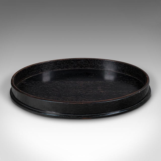 This is an antique oval trinkets tray. An English, ebony dressing table tidy, dating to the late Victorian period, circa...