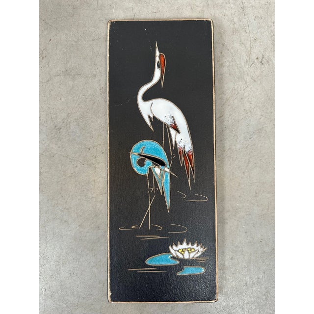 Two decorative wall plaques, West German pottery from the mid-20th century. Dark background with stylized images. One...