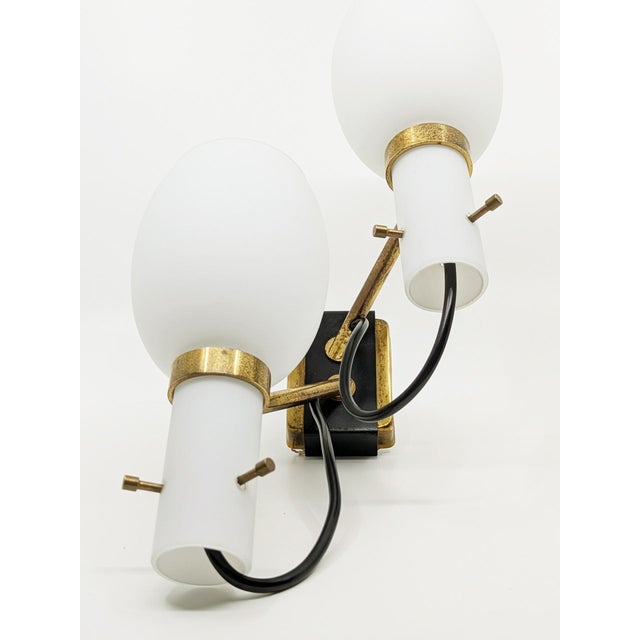 These sconces were designed in Italy around the 1950s in the Stilnovo style . they are made from a brass and black painted...