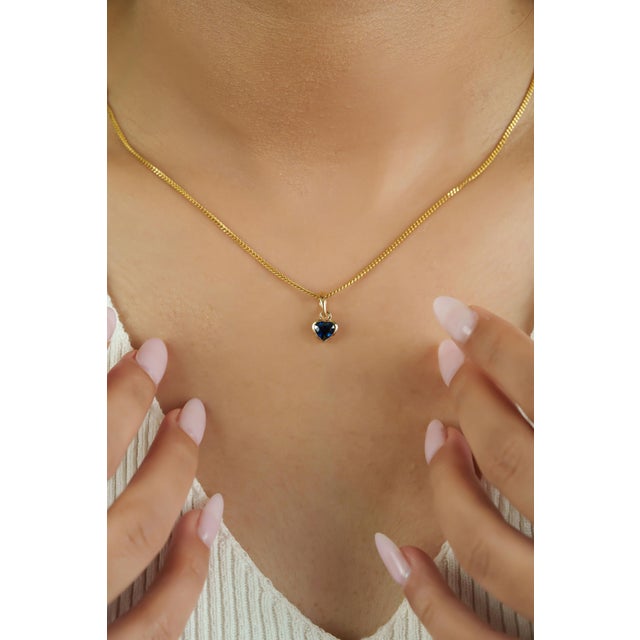 This elegant solitaire pendant features a 0.65 carat heart-shaped blue sapphire, set in 14k yellow gold. measuring 4.6 x 5...