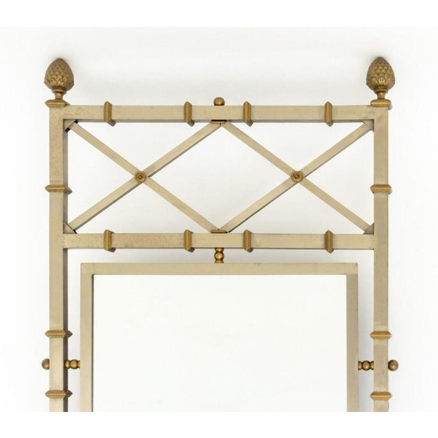 Maison Jansen Style Steel and Brass Mirror. Mirror plate: 33.75" H x 17.5" W; overall: 52" H x 24.5" W x 2" D. Provenance:...