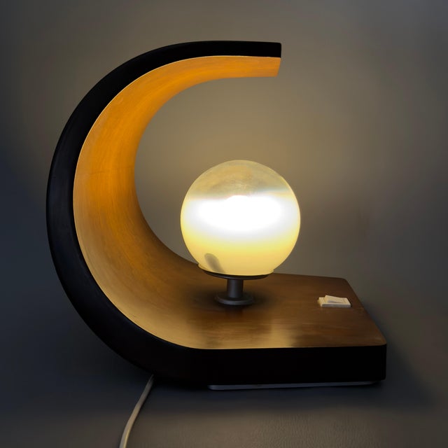 This sculptural table lamp represents a perfect synthesis of organic warmth and futuristic geometry, typical of the Space...