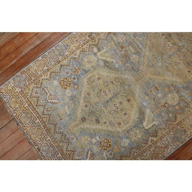 an early 20th Century Persian Tribal Shiraz Rug with yellow and brown accents on a light blue field Measures: 2'7'' x 4'1''.