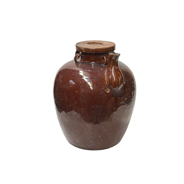 This is a 19th-century style ceramic oil pot. The pot has a rounded, somewhat bulbous body with a rich, dark brown glaze...