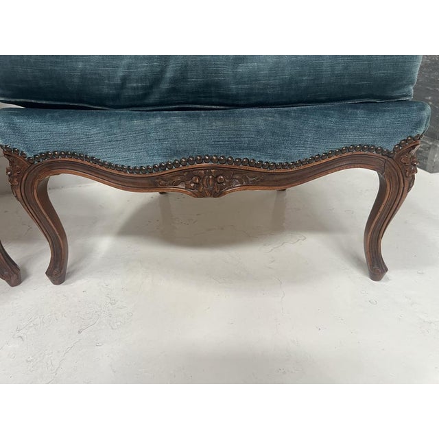 Pair of louis xv style bergère armchairs in natural wood stained beechwood frame carved with shell and floral motifs blue...