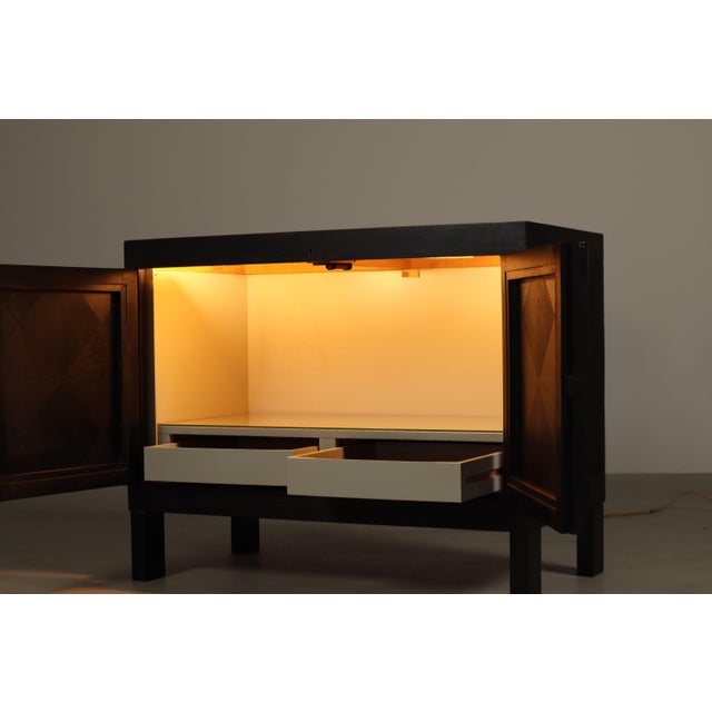 A compact brutalist bar cabinet designed by jean batenburg for mi, belgium, during the 1960s. executed in solid oak with a...