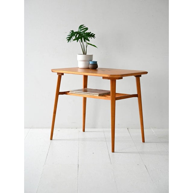 Scandinavian coffee table from the 1940s and 1950s in birch with a figurative inlaid top and a slatted lower shelf....
