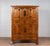 A Qing dynasty wooden cabinet from the late 19th century, with paneled doors, drawers and butterfly iron hardware. Created...
