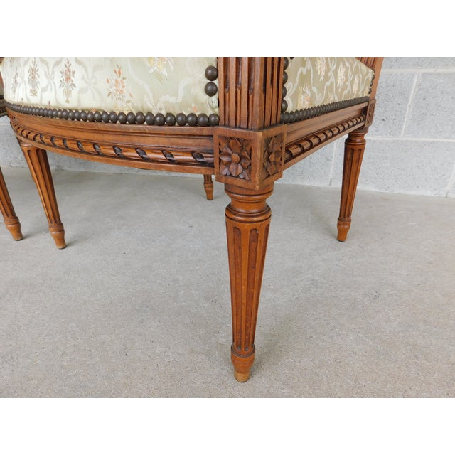 French pair of Louis XVI style armchairs from the Late 19th century. These antique chairs in Oak, with upholstered centers...