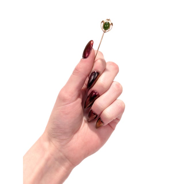 A fine antique Art Deco stickpin. In 14 karat yellow gold. By Krementz & Co. of Newark, NJ. With a bezel-set nephrite jade...