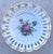 A collected 11-piece plate wall spanning from the late 19th century to the present day. Soft whites, whispers of lavender...
