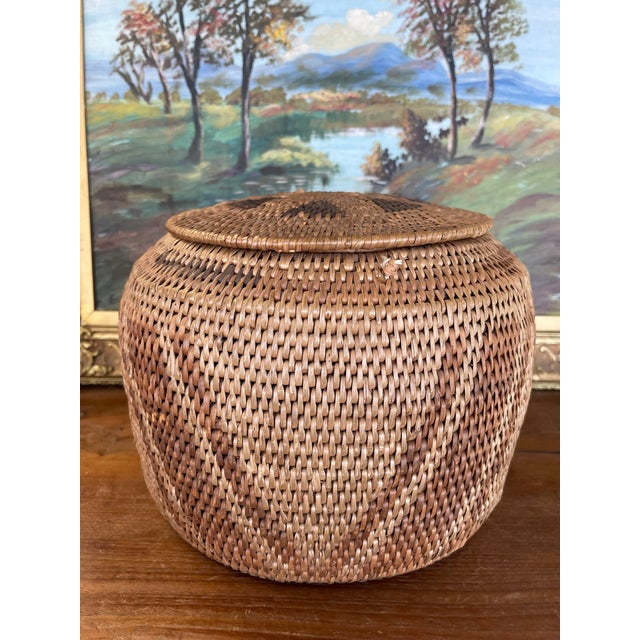 This vintage handwoven lidded basket is a finely executed example of traditional Southeast Asian basketry, likely...