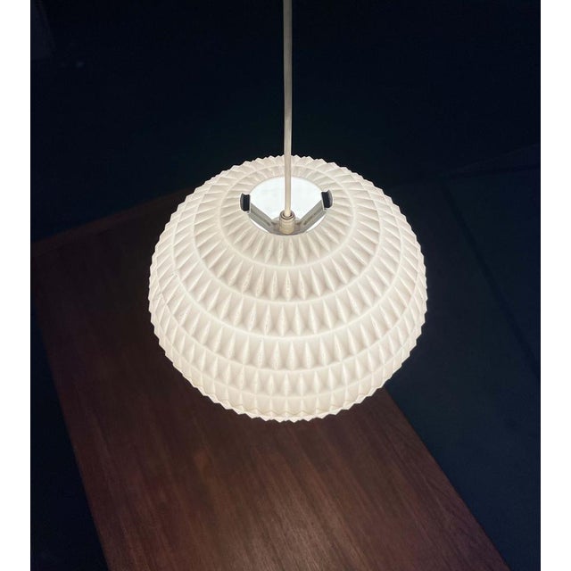 Mid-century pendant lamp by Erco, designed by Aloys Gangkofner. A design with a minimalist basic form and a complex...