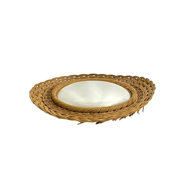 A charming vintage French convex mirror featuring a beautifully woven wicker frame in warm honey-gold tones. The layered,...