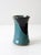 A striking studio pottery vase featuring a bold, hand-applied glaze of black, brown, and turquoise. The glossy finish and...