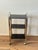 Vintage three-tier bar cart featuring a gold-tone metal frame, smoked plastic shelves.