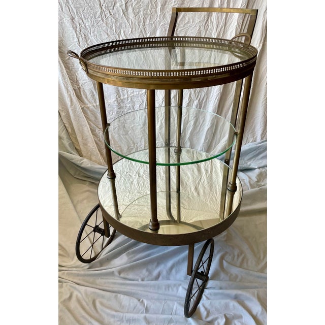 This brass bar cart with glass shelves and mirrored bottom has a wonderfully simple art deco style and is of fantastic...