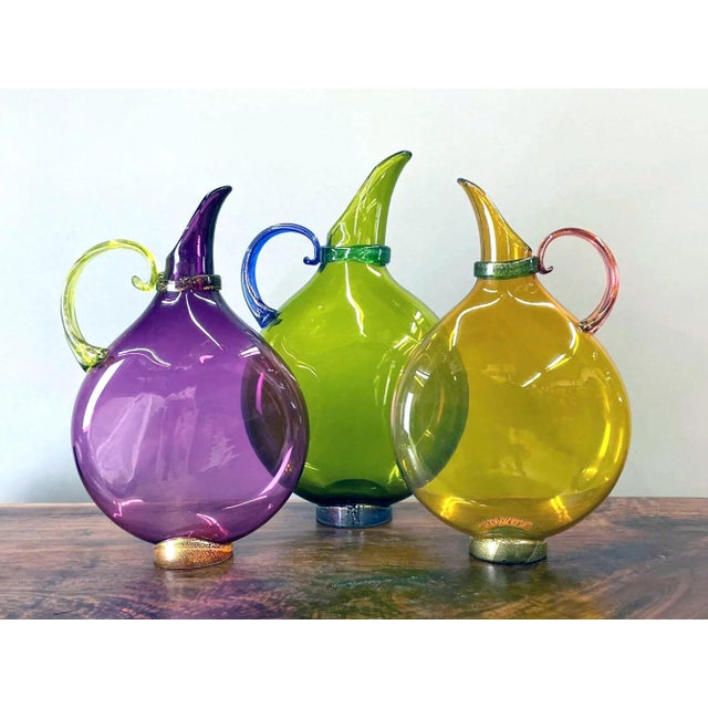 Michael Schunke Nine Iron Studios Hand-Blown Flat Art Glass Pitchers - Set of 3 Circa 2000–2007 Three jewel-colored...