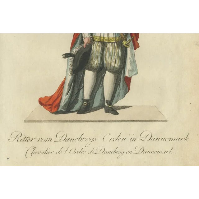 Knight of the Order of Dannebrog: 18th-Century Danish Chivalric Elegance This distinguished hand-colored engraving depicts...