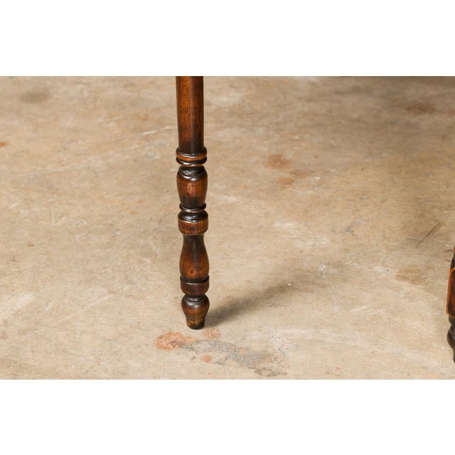 An English oak drop leaf table from the 19th century with slender turned legs, two lateral drawers and H-Form cross...