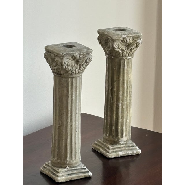 Offering a lovely vintage pair of Neoclassical-style cast plaster candlestick holders in the form of fluted Corinthian...