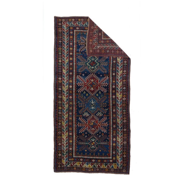 This large Kazak (long rug) on wool, with a moderate weave, features a well-abrashed dark blue field presenting six...