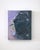 This oil painting features a close-up view of a helmet, capturing its metallic surface with a soft, reflective quality...