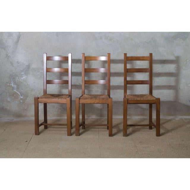 An elegant set of three 1950s French ladder-back dining chairs, expertly crafted from solid oak with hand-woven rush...