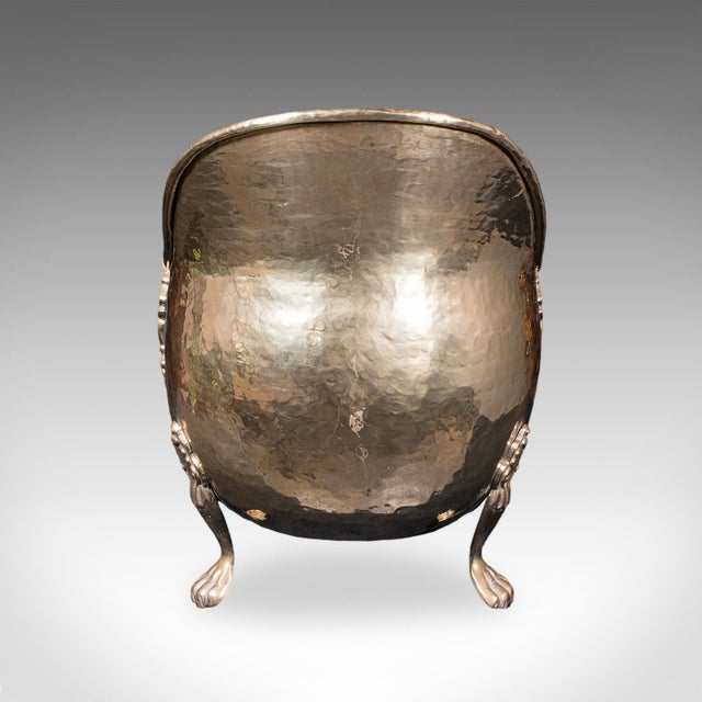 This is an antique fireside coal bucket. An English, brass fireplace log scuttle or keeper, dating to the Regency period,...
