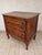 An antique French country commode with rich wood grain and beautifully worn details. This chest of drawers features two...
