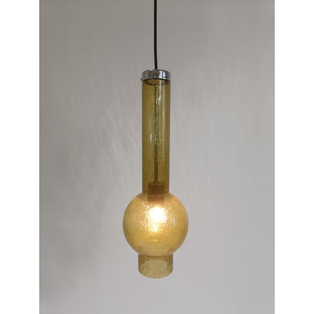 Beautiful tube shaped pendant lamp with bulge made by the German Staff Leuchten in the 60s. The amber/moss colored glass...