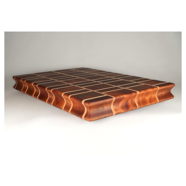 A bold and beautiful fusion of warm African Mahogany and bright Maple, this handcrafted end grain board features a clean...