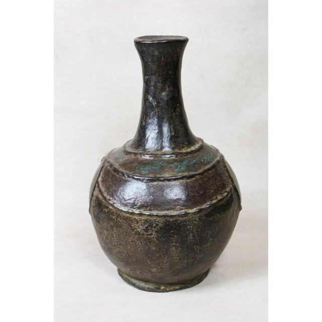 This Mangbetu Vase is a masterful blend of functional pottery and soulful sculpture, hand-crafted by the Mangbetu people...