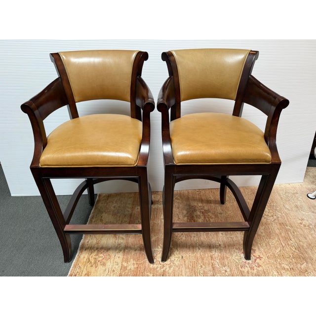 Design Plus Gallery presents a Pair of Leather Bar Stools from Woodbridge Furniture. The stools have a traditional...