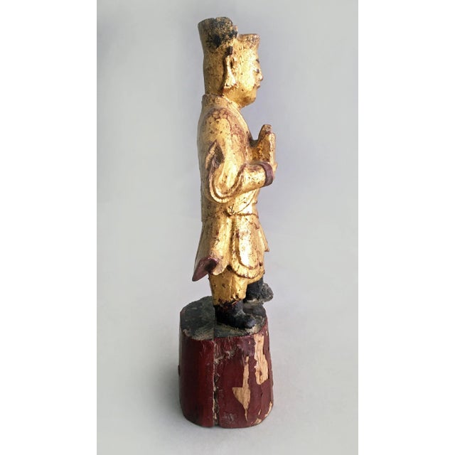Chinese hand-carved gilded standing figure, possibly a scholar holding a book, clad in robes and headdress, mounted on a...