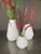 This is a set of three white hand-thrown contemporary vases with distinctive grooved texture. Pear-shaped, approximately...